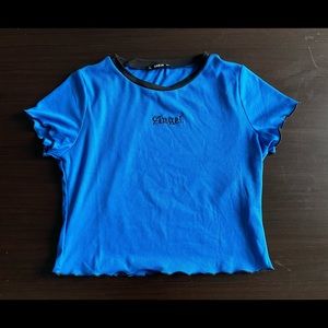 Blue crop top. "Angel" written in black on front.